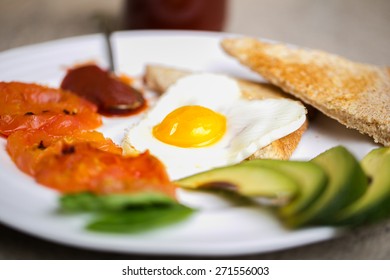 Healthy Breakfast Consisting Of Toast, Eggs, Avocado, Fried Tomato, And Relish 