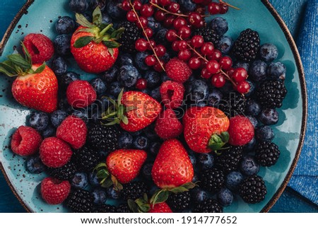 Healthy breakfast eating a mix of raw fresh berries fruits