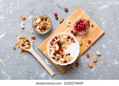 Healthy breakfast food with granola, yogurt, fruits and nuts. Dessert parfait with dried fruits for breakfast.