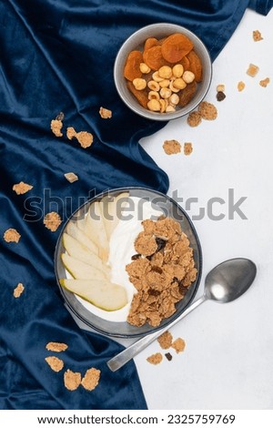 Healthy breakfast. Fresh muesli, muesli with yogurt, dried apricots and pear on a white background. Top view.