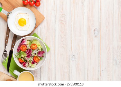 Healthy Breakfast With Fried Egg, Toasts And Salad On White Wooden Table. Top View With Copy Space