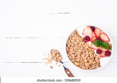 Healthy Breakfast With Granola, Berries And Yogurt On White Wooden Background. Healthy Eating Oatmeal. Top View. Copy Space