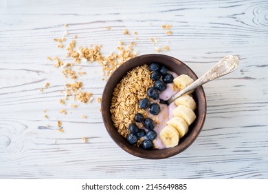 healthy breakfast, granola blueberry yogurt and banana in a dark plate on a white wooden background. The concept of proper nutrition, diet - Shutterstock ID 2145649885