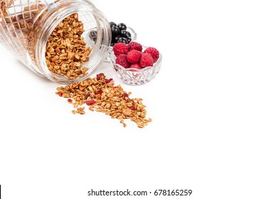 Healthy breakfast ingredients. Homemade oat granola with walnuts, cashew and dried cherry in glass cup, blackcurrant and raspberry. Isolated on white background. Copy space - Powered by Shutterstock