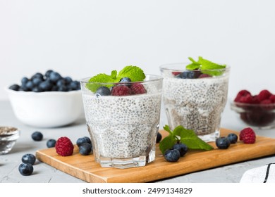 Healthy breakfast or morning with chia seeds vanilla pudding raspberry and blueberry berries on table background, vegetarian food, diet and health concept. Chia pudding with raspberry and blueberry. - Powered by Shutterstock