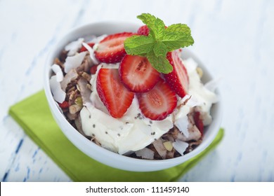 Healthy breakfast muesli made from oats, goji berries, shreded coconut, chia seeds, pepitas, cocoa, strawberry and greek yoghurt. - Powered by Shutterstock