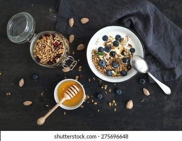 Healthy breakfast. Oat granola with fresh blueberries, almond, yogurt and mint in a rustic metal bowl over dark grunge surface - Powered by Shutterstock