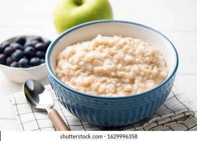 Healthy breakfast oatmeal porridge in bowl. Warm porridge oats, vegan vegetarian weight loss dieting breakfast food