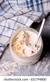 Healthy Breakfast Overnight Oats With Cocos And Banana In A Glass Jar, Close Up, Top View, Vertical