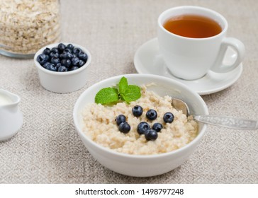 Healthy breakfast. porridge in a bowl with honey and berries and tea. Close-up - Shutterstock ID 1498797248
