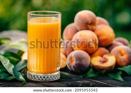 Healthy breakfast - ripe peaches, croissants and glass of freshly squeezed juice on table. Vegetarian food, vitamins, summer harvest from fruit tree. High quality photo