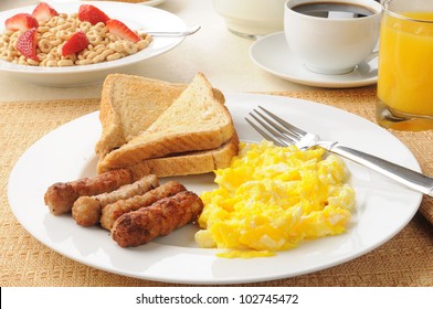 A Healthy Breakfast Of Sausage And Eggs With Orange Juice And Oat Cereal