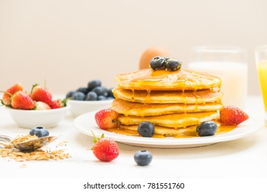 Healthy Breakfast set with Pancake and Granola with blueberry and strawberry and black coffee , Milk and Orange juice on white stone table background - Powered by Shutterstock