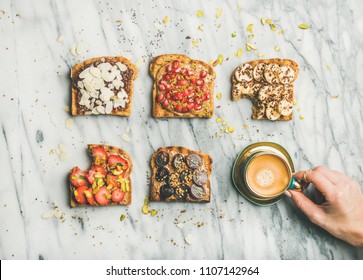 Healthy Breakfast, Snack. Flat-lay Of Vegan Wholegrain Toasts With Fruit, Seeds, Nuts, Peanut Butter, Cup Of Espresso And Female Hand Over Marble Background, Top View. Clean Eating Food Concept