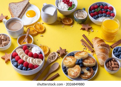 Healthy breakfast table scene with fruit, yogurts, croissants, smoothie, nutritious toasts and egg skillet. Top view over a yellow background. - Powered by Shutterstock