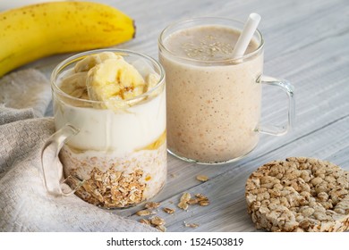 Healthy Breakfast. Two Glass Cups With Ingredients Banana, Honey, Oatmeal And Yogurt And Cooked Smoothie