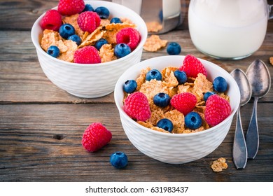 Healthy breakfast: whole grain cereals with raspberry and blueberry on wooden background - Powered by Shutterstock