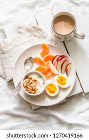 Healthy Breakfast - Yogurt With Granola, Fresh Fruit Apples, Tangerines And Coffee With Milk On A Light Background, Top View   