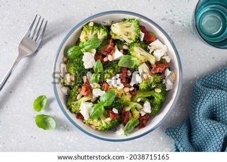 healthy broccoli salad with feta cheese sun dried tomatoes pine nuts.. vegetarian low carb keto diet