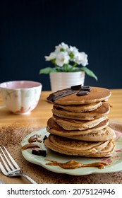 Healthy Buckwheat Pancake Stack With Dark Chocolate And Halvah Spread On A Decorative Plate. Easy To Make Gluten Free Morning Breakfast Or Brunch. Delicious Heap Of Golden Pancakes. Dark Background.