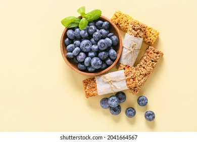 Healthy Cereal Bars And Blueberries On Color Background