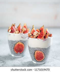 Healthy chia pudding with yogurt, figs and nuts in glass. Ideas and recipes for healthy breakfast, snack or dessert. Two glass with chia seeds pudding with copy space for text