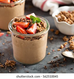Healthy chocolate banana smoothie with granola and fresh strawberry