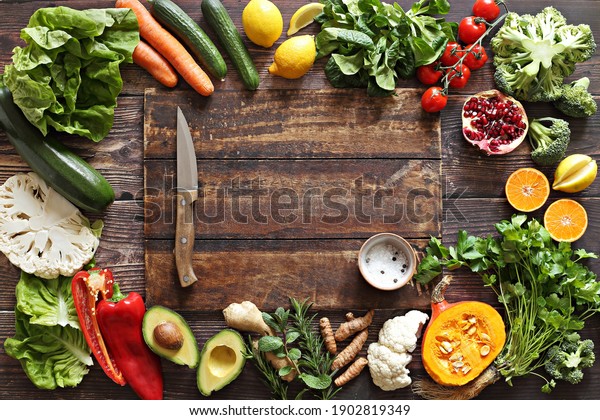 Healthy clean eating, plant based\
layout, vegetarian food and diet nutrition concept. Various fresh\
vegetables ingredients for cooking on dark wooden table\
