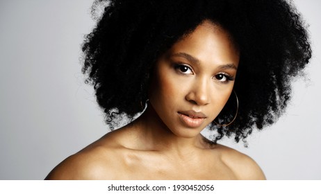 Healthy, Clean, Perfect Facial Skin. Beauty Portrait Of A Young Female Model Of Afro-appearance Posing. Working In A Photo Studio On A White Background. Black Healthy Curly Hair