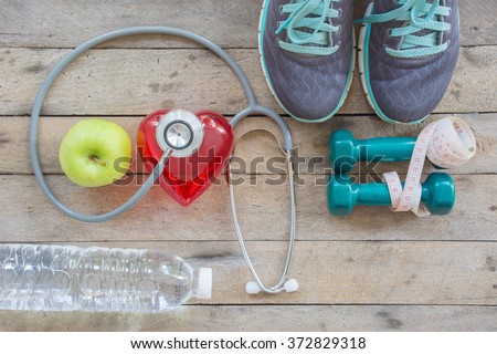 Healthy concept , diet plan with sport shoes and bottle of water and Dumbell on wooden background