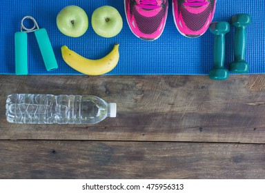 Healthy concept, Fitness equipment, yoga mat with sport shoes and healthy food on a wooden background