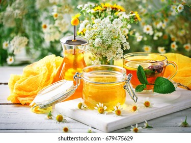 A healthy Cup of tea, a jar of honey and flowers. Selective focus. - Powered by Shutterstock