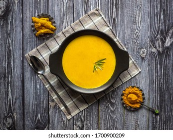 Healthy Curcuma Cream Soup On Black Wooden Background. Prevention Of Antiviral Infections. Spices For Ayurvedic Treatment. Alternative Medicine Concept.