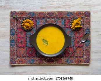 Healthy Curcuma Cream Soup On White Wooden Background. Prevention Of Antiviral Infections. Spices For Ayurvedic Treatment. Alternative Medicine Concept.