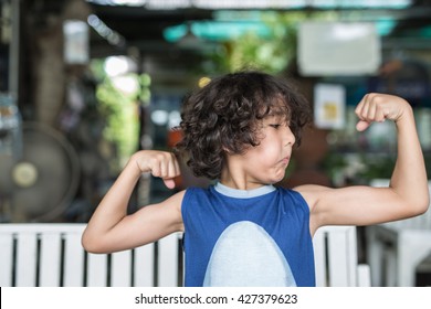 Healthy Curly Hair Strong Kid,boy Flexing, Muscle Strain His Arm As Healthy Development And Good Family Parenting,fitness Gym In Natural No Additive Workout,exercise And Fitness Plus Healthy Diet Food