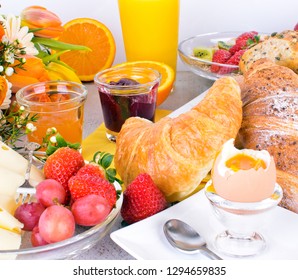 Healthy and delicious breakfast served with coffee, orange juice, croissants, rolls, cheese, egg, muesli and and fruits. Balanced diet. 
