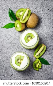 Healthy Dessert, Kiwi Yogurt Parfait In Glass Jars On Concrete Background. Top View, Space For Text.