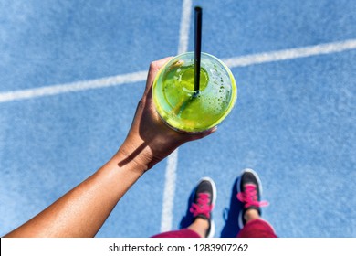 Healthy Detox Green Smoothie Cup Food Selfie Pov Showing Running Track And Runner Girl With Shoes Ready To Run. Square Social Media Instagram Crop.