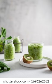 Healthy detox green smoothie with spinach, apple and kiwi in a glass with fresh ingredients on light background. Copy space for text, side view. Detox menu, dieting, healthy nutrition. - Shutterstock ID 1696262632