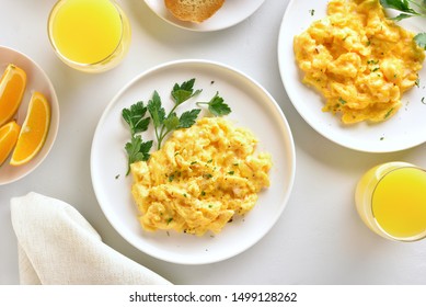 Healthy Diet Breakfast Concept. Scrambled Eggs And Orange Juice Over White Stone Background. Top View, Flat Lay