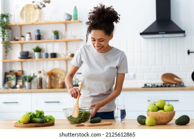 Healthy diet eating. African American young female preparing salad in home kitchen. Beautiful woman cooking healthy food, breakfast or dinner - Powered by Shutterstock