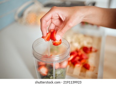 Healthy, diet and fruits while preparing a smoothie or shake in a blender at home. Making a fresh homemade organic drink with strawberries to cleanse and provide energy for vitality and health - Powered by Shutterstock