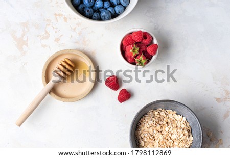 Zutaten für ein gesundes Frühstück mit Joghurt, Beeren und Chiasamen. Eine leere Schüssel, Draufsicht.