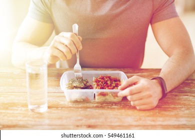healthy eating, balanced diet, food and people concept - close up of male hands having meat and vegetables for dinner with fork and water glass