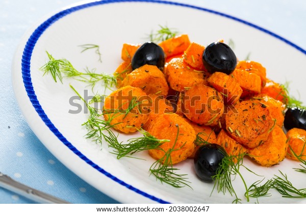 Healthy eating. Braised\
carrot slices with herbs de Provence and fresh dill garnished with\
black olives