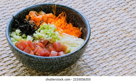 Healthy eating, clean food concept. Fish, vegetables, grains, seaweed. Traditional Hawaiian poke bowl with slices of fresh salmon and tuna standing on the table. Homemade healthy food. - Shutterstock ID 2155036355