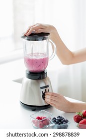 Healthy Eating, Cooking, Vegetarian Food, Dieting And People Concept - Close Up Of Woman Hands Blending Fruit Shake In Blender At Home