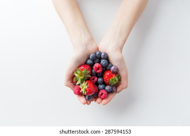 healthy eating, dieting, vegetarian food and people concept - close up of woman hands holding berries at home - Powered by Shutterstock