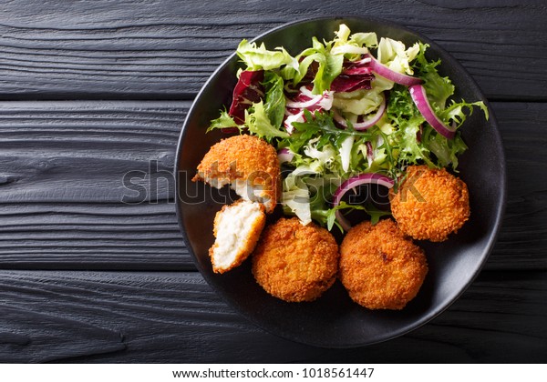 Healthy Eating:\
Fish cod cake and fresh salad close-up on a plate on the table.\
horizontal top view from\
above\
