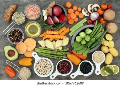 Healthy eating food with vegetables, fruit, grains, pulses, herbs, spice, olive oil and himalayan salt on marble background. Super foods high in antioxidants, vitamins, minerals and anthocyanins. - Shutterstock ID 1067762609